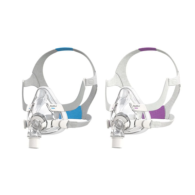 AirFit-F20 Dwa przezroczyste maski CPAP z kolorowymi paskami do terapii bezdechu sennego na białym tle.