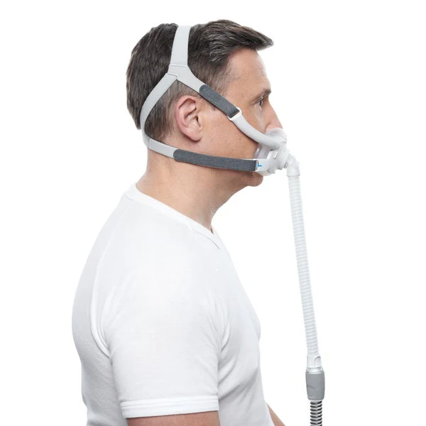 AirFitF40_Fitting_Male_8_720x Mężczyzna w masce CPAP do oddychania, widok z boku, białe tło.