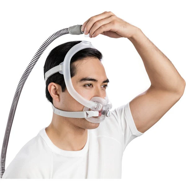 F30i_Fitting_Male_4_720x Mężczyzna zakłada maskę do terapii CPAP z rurką na głowie.