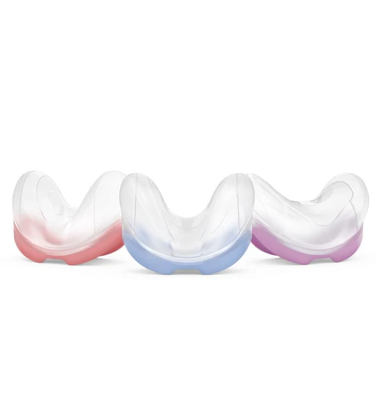 AirFit-N30-Cushion-3-sizes Trzy przezroczyste ochraniacze na zęby z kolorowymi podstawami: różową, niebieską i fioletową.