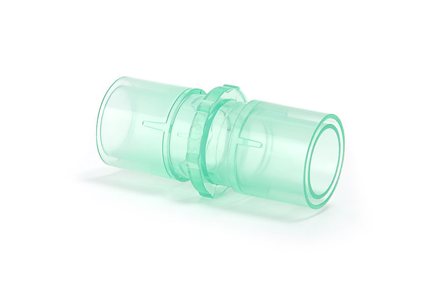 Przezroczysty, zielony łącznik plastikowy do rur medycznych na białym tle.